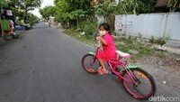 Anak-anak juga asyik bermain sepeda di jalanan yang sepi tersebut.