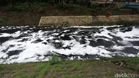 Aliran sungai memutih akibat tertutup busa.