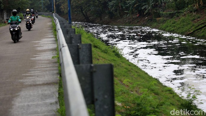 Sungai Buaran Jakarta Timur Berbusa Pengendara motor berjalan di Jalan Inspeksi Kali Buaran yang berbusa di Malaka Sari, Jakarta Timur, Rabu (15/7/2020). Busa ini diduga berasal dari limbah rumah tangga yang mencemari kali tersebut.