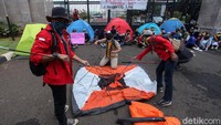 Sejumlah mahasiswa tampak sedang mendirikan tenda saat ikut serta dalam aksi menolak RUU Omnibus Law di depan Gedung DPR, Jakarta.