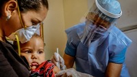 Seorang anak divaksinasi di Negara bagian Boliver, Venezuela. UNICEF mendistribusikan vaksin polio, demam kuning hingga tetanus di negara tersebut selama masa pandemi.