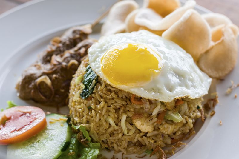 A popular fried rice dish in Indonesia and Malaysia. Served with egg, chicken satay, prawn crackers and salad garnish.