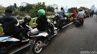 Pengendara motor yang berhenti membuat kemacetan kendaraan lain yang akan melintas.
