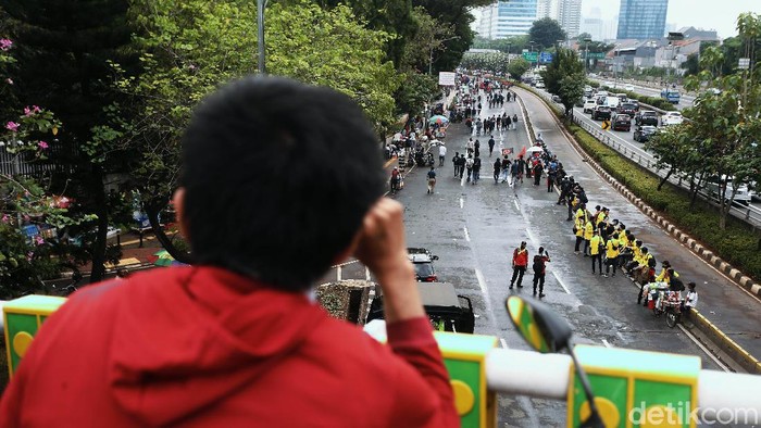 Massa PA 212 menggelar aksi menolak RUU HIP di depan Gedung DPR, Jakarta, Kamis (16/07/2020). 
Aksi mereka pun jadi tontonan para pengendara motor.