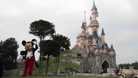 Karakter Mickey Mouse, sebagai ikon dari taman hiburan ini menyambut kembali para turis dengan melakukan tarian. (AP)