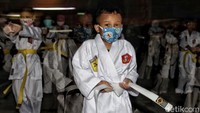 Seorang peserta mengencangkan ikatan sabuk putihnya sebelum mengikuti latihan karate. Selain sabuk putih, latihan juga diikuti peserta bersabuk kuning.