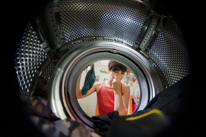 laundry woman viewed from a washing machine with a funny grim