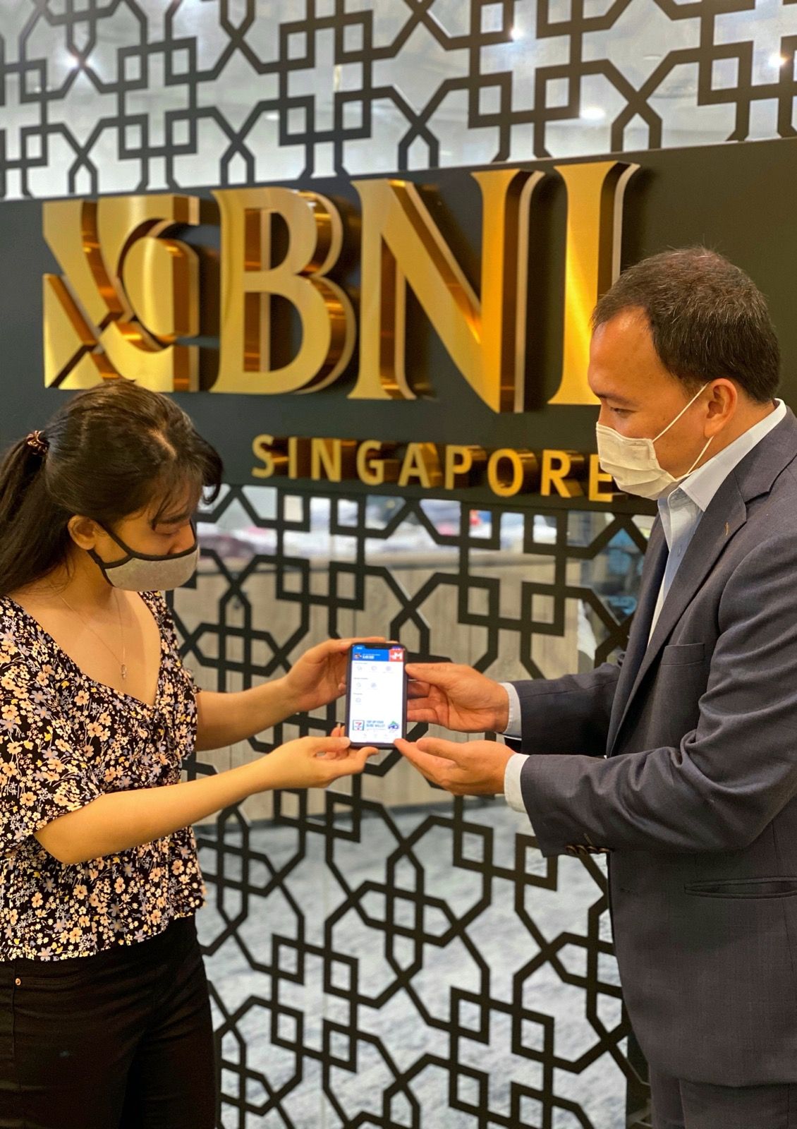 Pegawai sedang membantu nasabah untuk melakukan aktivasi BNI MoRe di Kantor Cabang BNI Singapura.