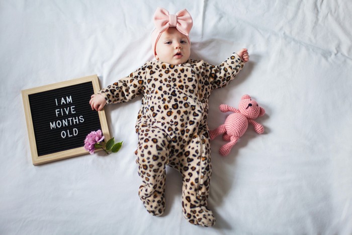 perkembangan bayi 5 bulan Baby reaching for colorful wooden blocks