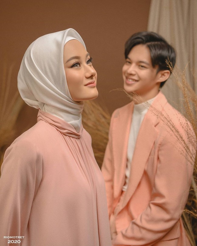 Dinda Hauw dan Rey Mbayang memakai konsep foto post-wedding warna pastel peach yang manis dan romantis. Keduanya mengenakan busana yang senada peach dan putih. Rey memakai coral suit dari Bima Wijaksana. Dinda mengenakan dress dari desainer Poppy Theodorin. Foto: instagram @riomotret