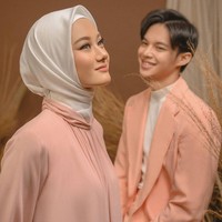 Dinda Hauw dan Rey Mbayang memakai konsep foto post-wedding warna pastel peach yang manis dan romantis. Keduanya mengenakan busana yang senada peach dan putih. Rey memakai coral suit dari Bima Wijaksana. Dinda mengenakan dress dari desainer Poppy Theodorin. Foto: instagram @riomotret