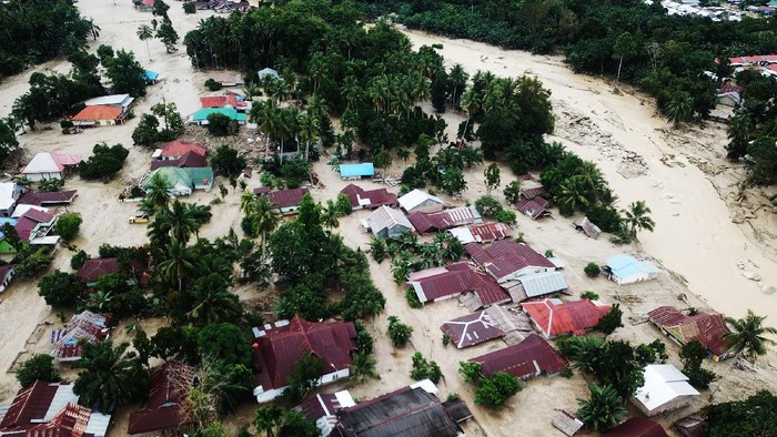 Potret Banjir Bandang di Luwu Utara dari Udara Foto udara kondisi perkampungan tertimbun lumpur akibat terjangan banjir bandang di Desa Radda, Kabupaten Luwu Utara, Sulawesi Selatan, Rabu (15/7/2020). Banjir bandang yang terjadi akibat tingginya curah hujan yang membuat sungai Salukula dan Meli meluap tersebut mengakibatkan 21 orang meninggal dunia dan puluhan warga dilaporkan masih dalam pencarian, sementara ratusan rumah rusak berat dan hilang tertimbun material lumpur. ANTARA FOTO/Moullies/ABHE/foc.