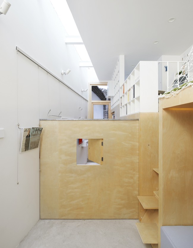 Lantai satu terdiri dari beberapa kotak kayu yang difungsikan sebagai ruang tamu, ruang makan, kamar tidur, ruang belajar dan kamar mandi. Setiap ruangan dipisahkan dengan sekat yang bisa digeser sehingga bisa menciptakan ruang yang lebih luas apabila ingin mengadakan pertemuan keluarga. Foto: Dok. Ruijing Photo/ B.L.U.E Architecture Studio