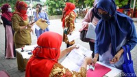Sejumlah petugas berjaga di area sekolah untuk mendata warga yang datan guna mendapatkan bantuan tersebut.