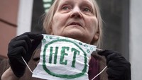 Tampak pula sejumlah demonstran yang ikut serta dalam aksi unjuk rasa tersebut membawa dan mengenakan masker bertanda No saat mengikuti demo di kawasan St. Petersburg, Russia. AP Photo/Dmitri Lovetsky.