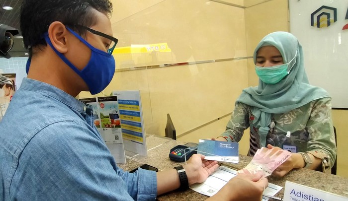 BTN Syariah Genjot Dana Murah Teller BTN Syariah sedang melayani nasabah menabung ke rekening tabungan BTN Qurban di Kantor Cabang Syariah BTN di Jakarta, Jumat (17/7). Menyambut hari raya Idul Adha, BTN Syariah mengenalkan Tabungan BTN Qurban ib yaitu produk tabungan untuk merencanakan pembelian dan penyaluran hewan qurban dengan bagi hasil yang menguntungkan dan kompetitif berdasarkan prinsip syariah dengan akad “Mudharabah Mutlaqah” (Investasi). Adapun program ini menjadi salah satu strategi BTN syariah menggenjot DPK, per Juni 2020 DPK BTN syariah menembus Rp 20,8triliun atau sudah 90 persen mencapai target tahun 2020.