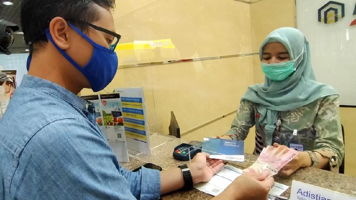 Teller BTN Syariah sedang melayani nasabah menabung ke rekening tabungan BTN Qurban di Kantor Cabang Syariah BTN di Jakarta, Jumat (17/7). Menyambut hari raya Idul Adha, BTN Syariah mengenalkan  Tabungan  BTN Qurban ib yaitu produk tabungan untuk merencanakan pembelian dan penyaluran hewan qurban dengan bagi hasil yang menguntungkan dan kompetitif berdasarkan prinsip syariah dengan akad “Mudharabah Mutlaqah” (Investasi). Adapun program ini menjadi salah satu strategi BTN syariah menggenjot DPK, per Juni 2020 DPK BTN syariah menembus Rp 20,8triliun atau sudah 90 persen mencapai target tahun 2020.