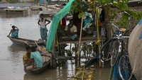 Orang-orang yang terkena dampak banjir India berlindung di bangunan sementara di dekat rumah mereka yang terendam. AP/Anupam Nath  