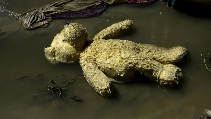 Warga mengangkat boneka di sekitar lokasi banjir bandang Masamba, Kabupaten Luwu Utara, Sulawesi Selatan, Jumat (17/7/2020). Hingga hari ini, jumlah korban meninggal mencapai 32 orang sementara puluhan lainnya masih dalam pencarian. ANTARA FOTO/Abriawan Abhe/pras.
