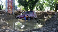 Warga korban banjir bandang melihat kondisi kendaraannya yang terseret material lumpur di kecamatan Masamba, Kabupaten Luwu Utara, Sulawesi Selatan, Jumat (17/7/2020).
