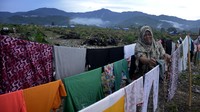 Warga korban banjir bandang sedang menjemur baju.