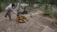 Seorang kerabat menunjukkan makam Nadeem Jordon yang tewas ditembak karena menyewa di lingkungan muslim. AP Photo/Muhammad Sajjad.