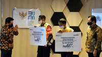Wakil Direktur Utama Bank Mandiri Hery Gunardy (kiri) didampingi  Presiden Direktur PT AXA Mandiri Financial Services (AXA Mandiri) Handojo Gunawan Kusuma (kanan) menyerahkan apresiasi secara simbolis berupa asuransi jiwa senilai Rp 500 juta kepada kedua petugas KRL, Egi Sandi Saputra (kedua kanan) dan Mujenih (kanan), di Synergy Lounge Kementerian BUMN, Jakarta, Senin (13/7).
