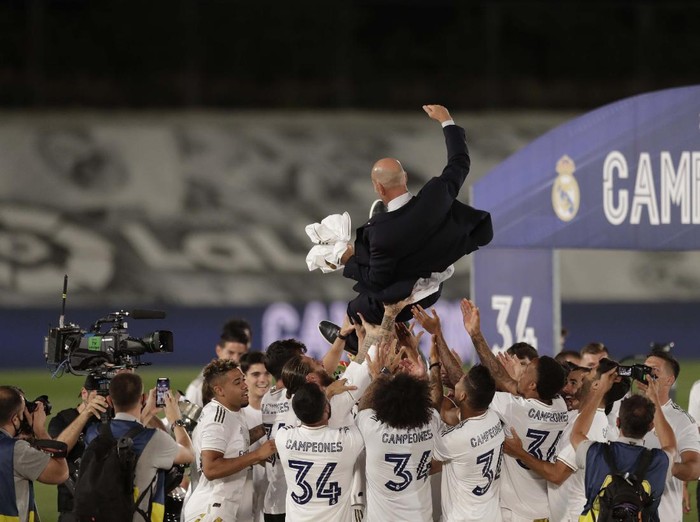 Real Madrid's head coach Zinedine Zidane, holds the trophy as he poses for the photographers after winning the Spanish La Liga 2019-2020 following a soccer match between Real Madrid and Villareal at the Alfredo di Stefano stadium in Madrid, Spain, Thursday, July 16, 2020. (AP Photo/Bernat Armangue)