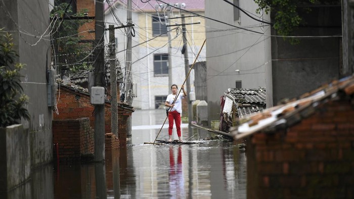 A woman pushes a makeshift raft down a flooded alleyway in a village in Yongxiu in central eastern Chinas Jiangxi province, Thursday, July 16, 2020. Engorged with more heavy rains, Chinas mighty Yangtze River is cresting again, bringing fears of further destruction. (Chinatopix via AP)