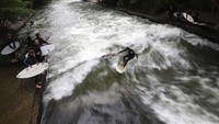 Di Eisbach, para peselancar berusaha menaklukan arus sungai tersebut. Mereka datang mengenakan baju selancar, lengkap dengan papan surfingnya.