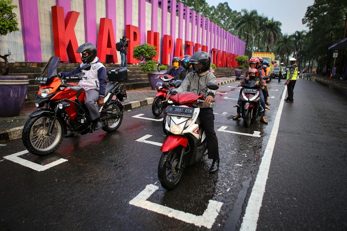 Sejumlah pengendara sepeda motor berhenti di ruang henti yang diberi tanda jaga jarak di kawasan Jalan Baru, Tigaraksa, Kabupaten Tangerang, Banten, Jumat (17/7/2020). Polresta Tangerang dan Dinas Perhubungan Kabupaten Tangerang memberikan tanda jarak di persimpangan tersebut untuk membatasi jarak antar pengendara guna mencegah penyebaran COVID-19. ANTARA FOTO/Fauzan/wsj.