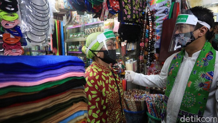 Wakil Gubernur DKI Jakarta Ahmad Riza Patria (tengah) memberikan kantong belanja ramah lingkungan kepada pedagang di Pasar Tebet Barat, Jakarta, Jumat (17/7/2020). Kegiatan tersebut dalam rangka kampanye penggunaan kantong belanja ramah lingkungan guna meminimalisir pemakaian kantong plastik.