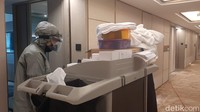 Para petugas mengenakan alat pelindung lengkap untuk membersihkan kamar yang sudah diinapi tamu. (Riska/detikcom)
