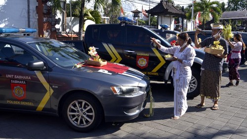 Pemuka agama Hindu dan petugas kepolisian mengupacarai persenjataan saat rangkaian persembahyangan Hari Raya Tumpek Landep di Polsek Denpasar Selatan, Bali, Sabtu (18/7/2020). Hari Tumpek Landep dirayakan umat Hindu untuk melakukan pembersihan dan penyucian dengan makna memohon penajaman pikiran dalam menggunakan ilmu pengetahuan serta teknologi yang disimboliskan dengan mengupacarai persenjataan atau peralatan berbahan besi yang sifatnya tajam. ANTARA FOTO/Fikri Yusuf/hp.