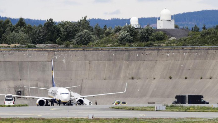 A picture taken on July 17, 2020 shows an aircraft of Irish low-cost carrier Ryanair on the tarmac of the Gardemoen airport about 50 kilometres (30 miles) northeast of the Norwegian capital, where the aircraft landed safely after a bomb threat. - A British national was arrested after a Ryanair plane flying from London to Oslo received a bomb threat, Norwegian police said, the second threat against a Ryanair flight in a week. Fighter jets from neighbouring Denmark escorted the plane to Oslo. (Photo by Berit Roald / NTB Scanpix / AFP) / Norway OUT