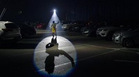Seorang performer menunjukkan kemampuan atraksinya di hadapan para pengunjung yang datang ke sirkus drive-in di kawasan Rio de Janeiro, Brasil, Sabtu (18/7/2020) waktu setempat.