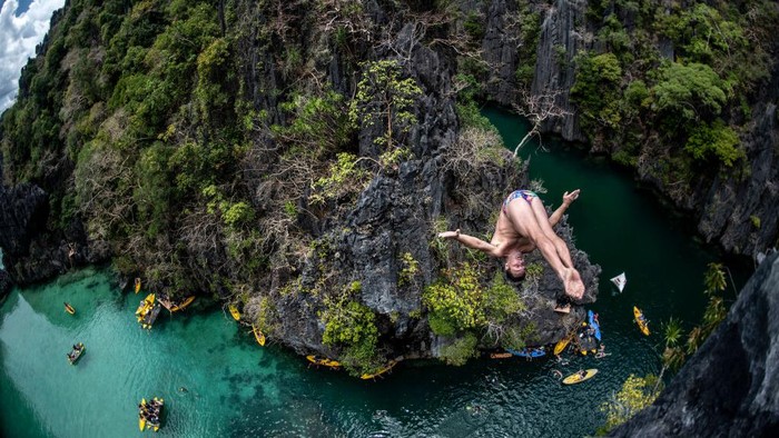 Aksi Lompat Bebas di Pulau Palawan Filipina PALAWAN, PHILIPPINES - APRIL 12: (EDITORIAL USE ONLY) In this handout image provided by Red Bull, Blake Aldridge of the UK dives from a rock pinnacle at the Small Lagoon on Miniloc Island during the first competition day of the first stop of the Red Bull Cliff Diving World Series on April 12, 2019 at Palawan, Philippines. (Photo by Dean Treml/Red Bull via Getty Images)