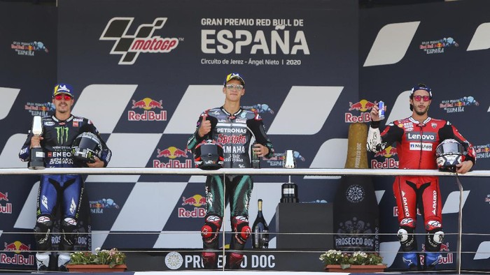 Race winner Fabio Quartararo of France, center, celebrates at the podium with Maverick Vinales of Spain, left, and Andrea Dovizioso of Italy at the end of the Spanish Motorcycle Grand Prix at the Angel Nieto racetrack in Jerez de la Frontera, Spain, Sunday, July 19, 2020. (AP Photo/David Clares)