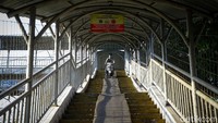 Pengendara sepeda motor nekat melintasi Jembatan Penyebrangan Orang (JPO) di kawasan Rawa Jati, Jakarta Selatan, Senin (20/7/2020).