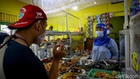 Tak hanya pengunjung, pedagang warung pun juga mengenakan masker dan face shield maupun pelindung wajah saat melayani pelanggan di warung tersebut.