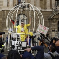 Desainer asal Inggris Vivienne Westwood beraksi dari dalam sangkar raksasa saat ikut serta di aksi unjuk rasa menolak ekstradisi Julian Assange, pendiri WikiLeaks di kawasan London, Selasa (21/7/2020). AP Photo/Matt Dunham.