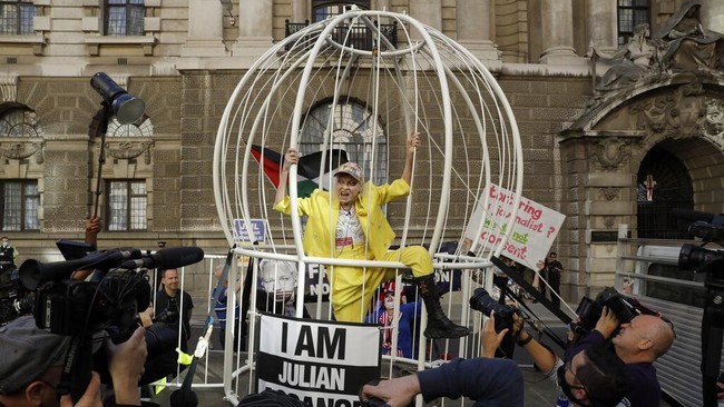 Desainer asal Inggris Vivienne Westwood beraksi dari dalam sangkar raksasa saat ikut serta di aksi unjuk rasa menolak ekstradisi Julian Assange, pendiri WikiLeaks di kawasan London, Selasa (21/7/2020). AP Photo/Matt Dunham.