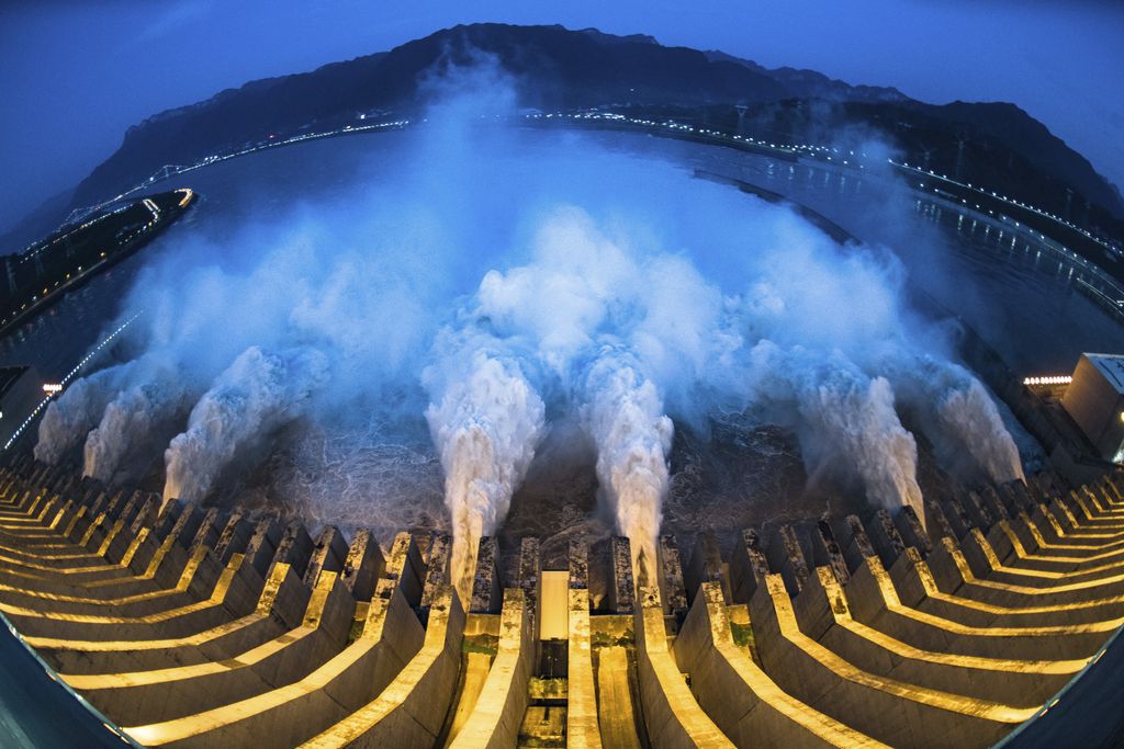 In this image made with fisheye lens and provided by Xinhua News Agency, floodwaters are discharged at the Three Gorges Dam in central China's Hubei province on Sunday, July 19, 2020. Authorities in the neighboring province of Anhui blasted a dam Sunday to release surging waters behind it amid widespread flooding across the country that has claimed scores of lives. (Xiao Yijiu/Xinhua via AP)