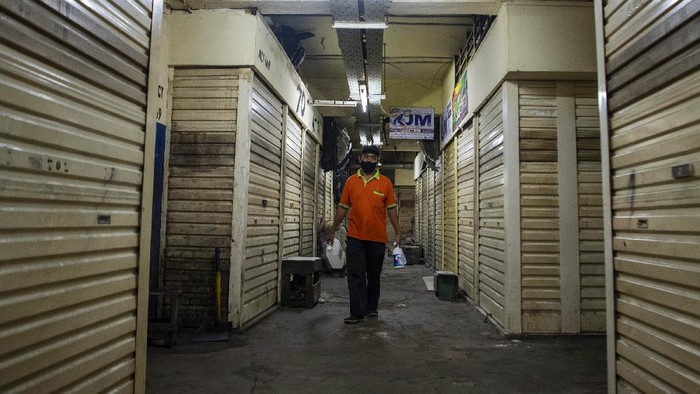 Petugas keamanan berjalan di depan toko yang tutup di Pasar Asem Reges, Jakarta Barat, Selasa (21/7/2020). Pengelola Pasar Asem Reges menutup sementara pasar tersebut dari Senin (20/7) hingga Rabu (22/7) menyusul satu orang pedagang terkonfirmasi positif COVID-19 berdasarkan hasil tes usap (swab test).