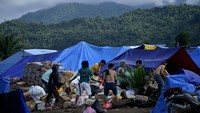 Warga korban banjir bandang yang mengungsi di perbukitan Desa Meli, Baebunta, Luwu Utara, menerima bantuan logistik. 
