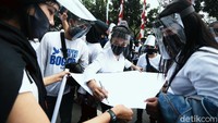 Sejumlah peserta aksi tampak memakai face shield.