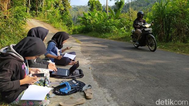 Teara (tengah), mahasiswi yang mengerjakan tugas daring di pinggir jalan di Magelang, Selasa (21/7/2020).