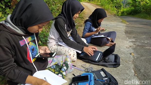 Teara (tengah), mahasiswi yang mengerjakan tugas daring di pinggir jalan di Magelang, Selasa (21/7/2020).