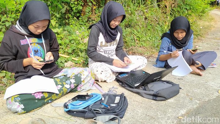 Teara (tengah), mahasiswi yang mengerjakan tugas daring di pinggir jalan di Magelang, Selasa (21/7/2020).