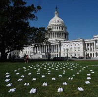 Pada Selasa (21/7/2020), para perawat menaruh 164 pasang sepatu putih di halaman depan Gedung Parlemen Amerika Serikat, Washington, D.C. Foto: AFP/OLIVIER DOULIERY